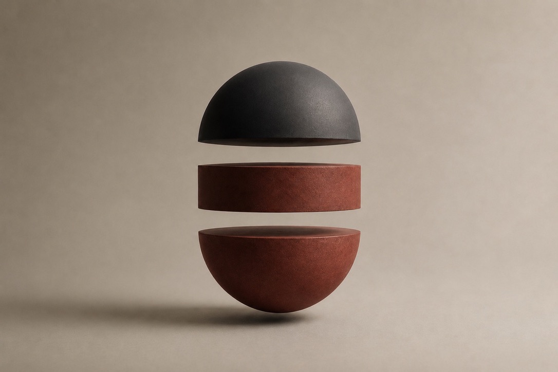 A sphere opened into three floating components - dark cap, red core, red base